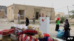 People collect their belongings from the rubble of their damaged house in the town of Shonbeh, southeast of Bushehr.