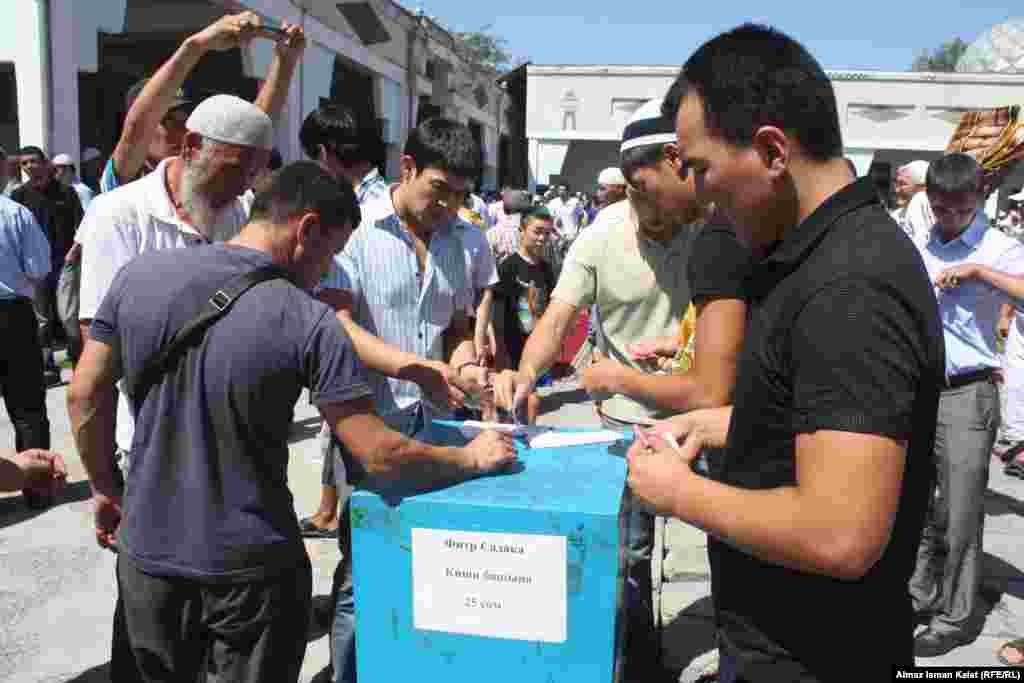 Бишкек. Верующие в центральной мечети делают пожертвование после пятничного намаза