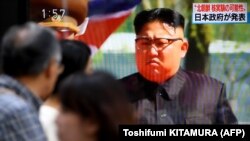 Japan -- Pedestrians walk past a television screen broadcasting a television news programme on a possible North Korean nuclear test in Tokyo on September 3, 2017. North Korea appeared to carry out a sixth nuclear test on September 3, with seismic monitor