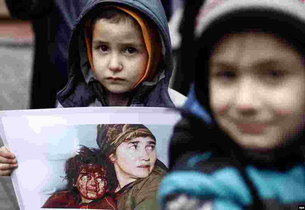 A refugee child from the Caucasus holds a banner during a protest in Istanbul against Russian President Vladimir Putin's visit to Turkey. Members of the Caucasian refugee community in Turkey say Putin has presided over a policy that has violently targeted members of the community. (epa/Sedat Suna)