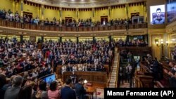Parlamentarët duartrokasin presidentin e Ukrainës, Volodymyr Zelensky, i cili përmes ekranit i drejtohet dhomës plenare në parlamentin spanjoll në Madrid, Spanjë. 5 prill 2022.