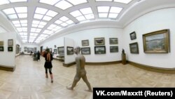 A gold-painted art lover who was wearing only a red thong strolled through the Tretyakov Gallery in Moscow on March 20.