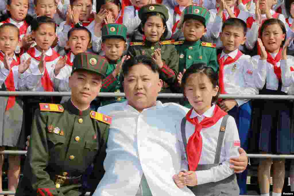 Schoolchildren stand beside North Korean leader Kim Jong Un as he arrives to attend We Are The Happiest In The World, a performance of schoolchildren to celebrate the 70th founding anniversary of the Korean Children's Union in Pyongyang. (Reuters/KCNA)