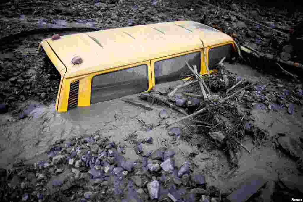 A vehicle is buried in mud in Topcic Polje, Bosnia-Herzegovina.