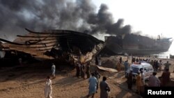 Rescue workers and family members of missing laborers gather and wait near the burning oil tanker at the Gadani ship-breaking yard some 45 kilometers of Karachi on November 2.