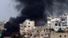 Дым над кварталом Баб-аль-Теббанех во время одного из столкновений с алавитами, снимок 2012 года