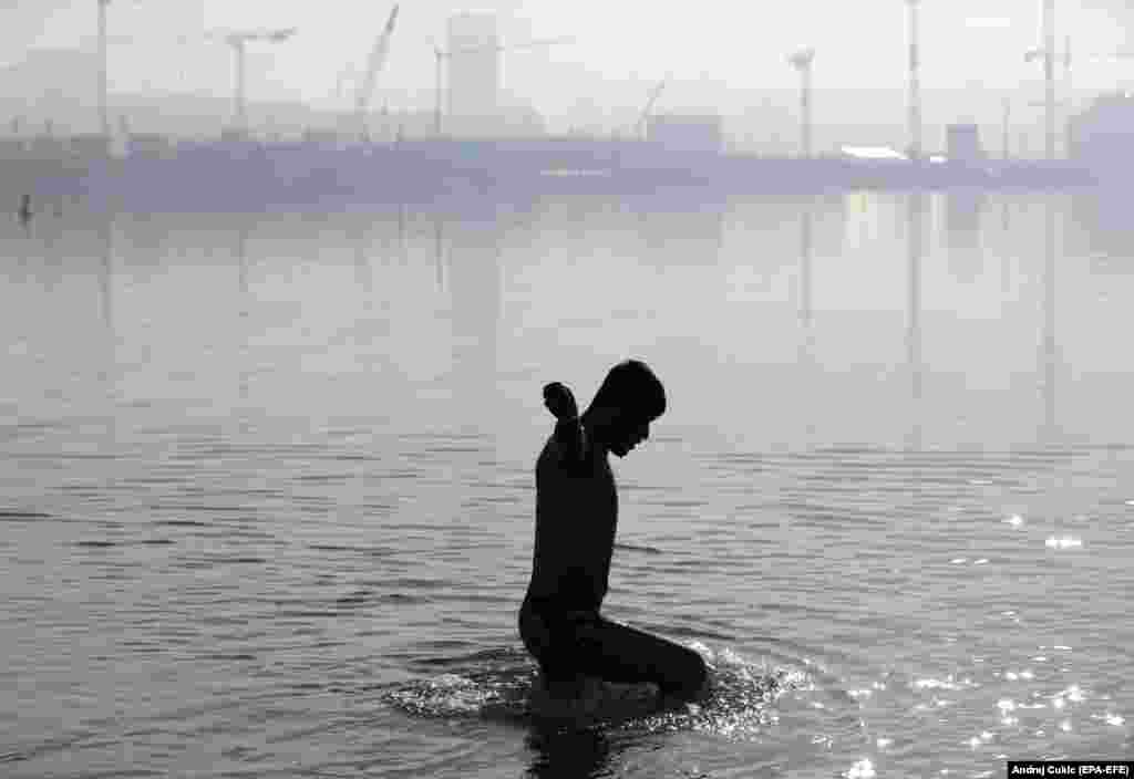 A migrant from Afghanistan bathes in the Sava River in Belgrade, Serbia. (epa-EFE/Andrej Cukic)