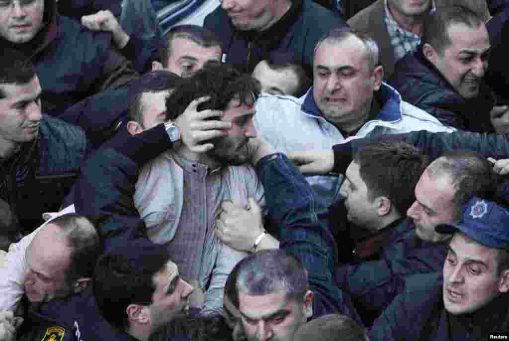 Protesters scuffle outside the National Library in the Georgian capital, Tbilisi. Hundreds of protesters gathered in an attempt to block President Mikheil Saakashvili from entering the building to deliver his last annual address to the nation. (Reuters/David Mdzinarishvili)