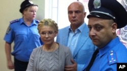 Yulia Tymoshenko inside the court hearing room with her husband, Oleksandr, in Kyiv on August 11.