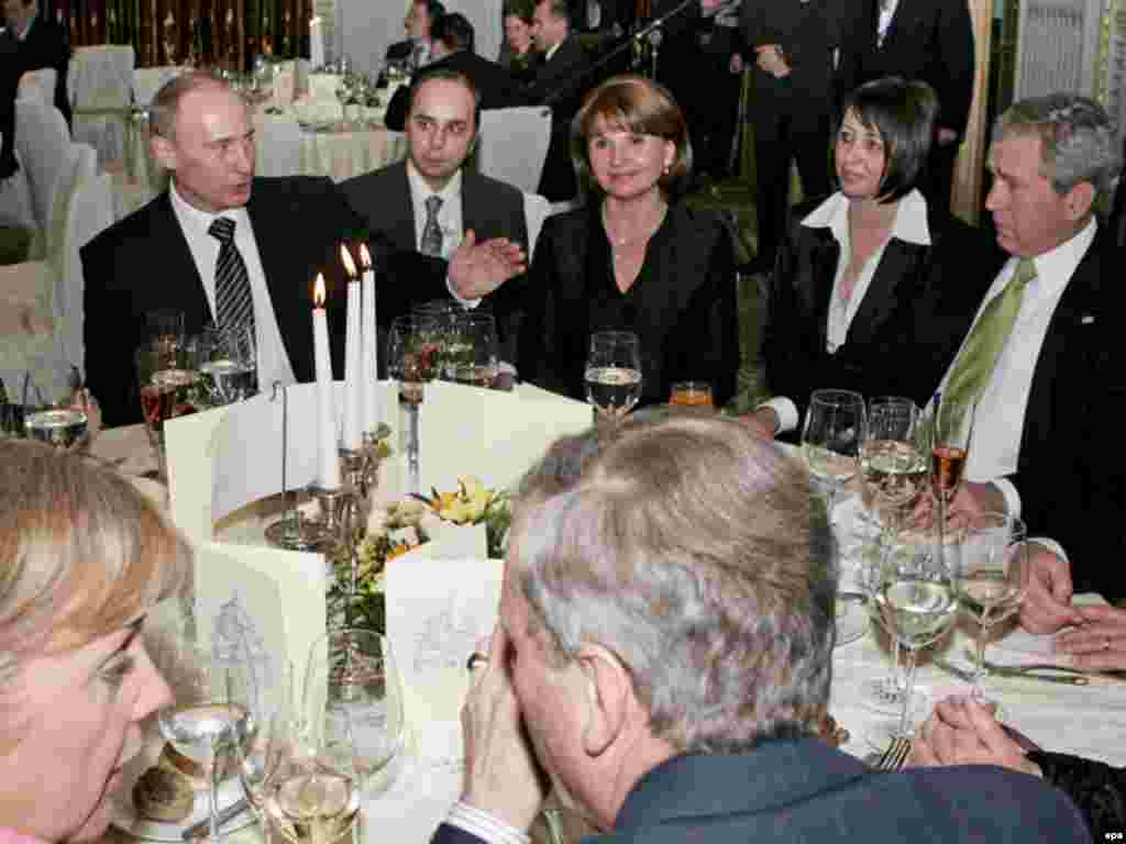 Канцлер Німеччини Анґела Меркель, Президент Росії Путін та Президент США Джордж Буш на урочистій вечері 3 квітня - Caption: epa01304173 Germany's Chancellor Angela Merkel (front L), Russia's President Vladimir Putin (background, L) and US President George W. Bush (R) attend an official dinner in Bucharest, Romania, 03 April 2008. Putin arrived in Bucharest late 03 April 2008 to take part in the meeting of the NATO- Russia Council on 04 April. EPA/VLADIMIR RODIONOV - POOL