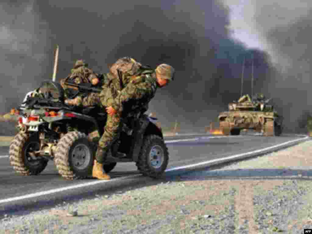 GEORGIA, GORI : A Georgian soldier jumps from his quad as a Russian rocket fire hits a convoy of departing Georgian troops just outside Gori on August 11, 2008. Russian forces have occupied the city of Gori and Georgian forces are fortifying positions near Tbilisi to defend the capital, the secretary of Georgia's security council, Alexander Lomaia. AFP PHOTO/ DIMITAR DILKOFF