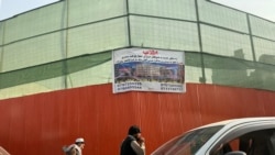 Afghans walk by the site of the demolished historical Ariana Cinema in Kabul on December 18. The Taliban government's move to destroy the theater is considered by a number of Afghan cultural figures, filmmakers, and actors to be an attack on the country's cultural heritage.<br><br>