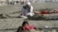 9 ýaşly maýyp gyzjagaz guma gömülmek arkaly bejergi alýar, Karaçi, Pakistan, 2011-nji ýylyp 4-nji ýanwary.