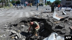 Вибухотехнік працює на місці влучення російської авіаційної бомби в центрі Харкова, 22 червня 2024 року