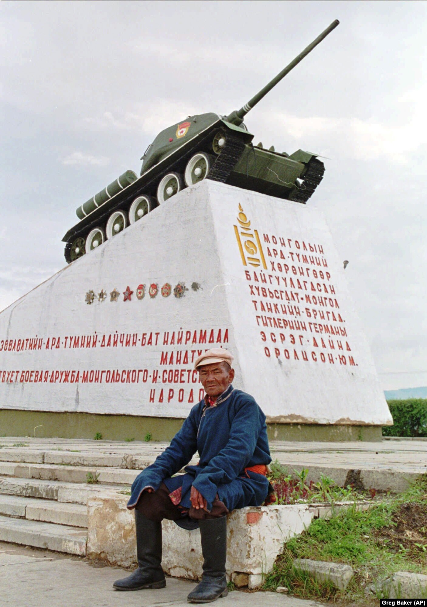 Një burrë mongol në shkallët e një monumenti në Ulan Bator, që përkujton mbështetjen e këtij vendi ndaj Bashkimit Sovjetik, gjatë Luftës së Dytë Botërore. Fotografia u bë në Mongolinë e pavarur në vitin 1996.