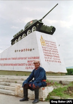 A Mongolian man on the steps of a monument in Ulan Bator commemorating the country's support of the Soviet Union during World War II. The photo was taken in independent Mongolia in 1996.