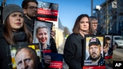 Belarusian opposition leader Svyatlana Tsikhanouskaya, second from right, holds a portrait of her jailed husband Syarhey Tsikhanouski, attend a protest demanding freedom for political prisoners in Belarus in March 2024. 