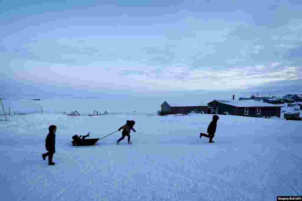 Children play in the snow in Toksook Bay beside the Bering Sea in Alaska.&nbsp; (AP/Gregory Bull)