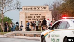 News media gather outside one of the entrances to the Fort Hood military base near Killeen, Texas, on April 2.