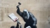 A rendszerint közéleti témákban alkotó streetart művész valószínűleg a tiltott Palesztin Akció csoportot támogató több száz tüntető letartóztatását kommentálta ezzel a falfestménnyel – írja a Reuters