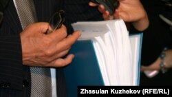 Депутат мажилиса парламента Ирак Елекеев продемонстрировал журналистам объем папки с описанием вносимых в Налоговый кодекс Казахстана поправок. Астана, 13 октября 2010 года.