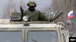 Қримда махсус нишонларсиз ҳарбий кийимда юрган аскарлар Россияга қарашли эканига оид тахминларни Путин инкор қилмоқда.