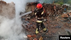 Vatrogasac pored zgrade uništene u ruskom napadu drona u gradu Priluki, Černihivska oblast, Ukrajina, 5. juni 2025.