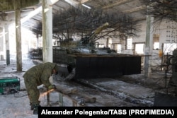 A mechanic cuts a length of metal tubing inside the Zaporizhzhya workshop.