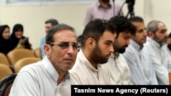 Vahid Mazloumin (L) is seen appearing in court for the first time on charges of manipulating the currency market. He was later sentenced to death, in Tehran, September 8, 2018