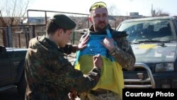 Боєць 24-ї бригади підписує прапор України для волонтерів і музею АТО в Червонограді
