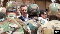 Syrian President Bashar al-Assad greets Syrian army soldiers in Daraya on August 1.
