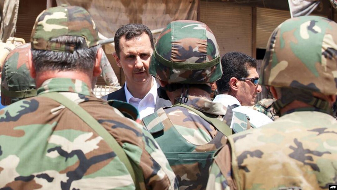 Syrian President Bashar al-Assad greets Syrian army soldiers in Daraya on August 1.