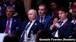 Kosovar President Hashim Thaci (left) sat alongside Russian President Vladimir Putin and Canadian Prime Minister Justin Trudeau.