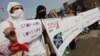 FILE: People hold placards during a rally to create awareness about HIV/AIDS. 