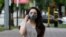 Kazakhstan. A girl in a protective mask is walking along the street of Almaty. June 22, 2020