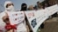 FILE: People hold placards during a rally to create awareness about HIV/AIDS. 