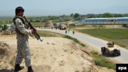 FILE: An Afghan security soldier overlooking a battle with the Taliban fighters in Kunduz.