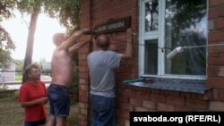 Вешаюць шыльду на хату Рыгора Барадуліна