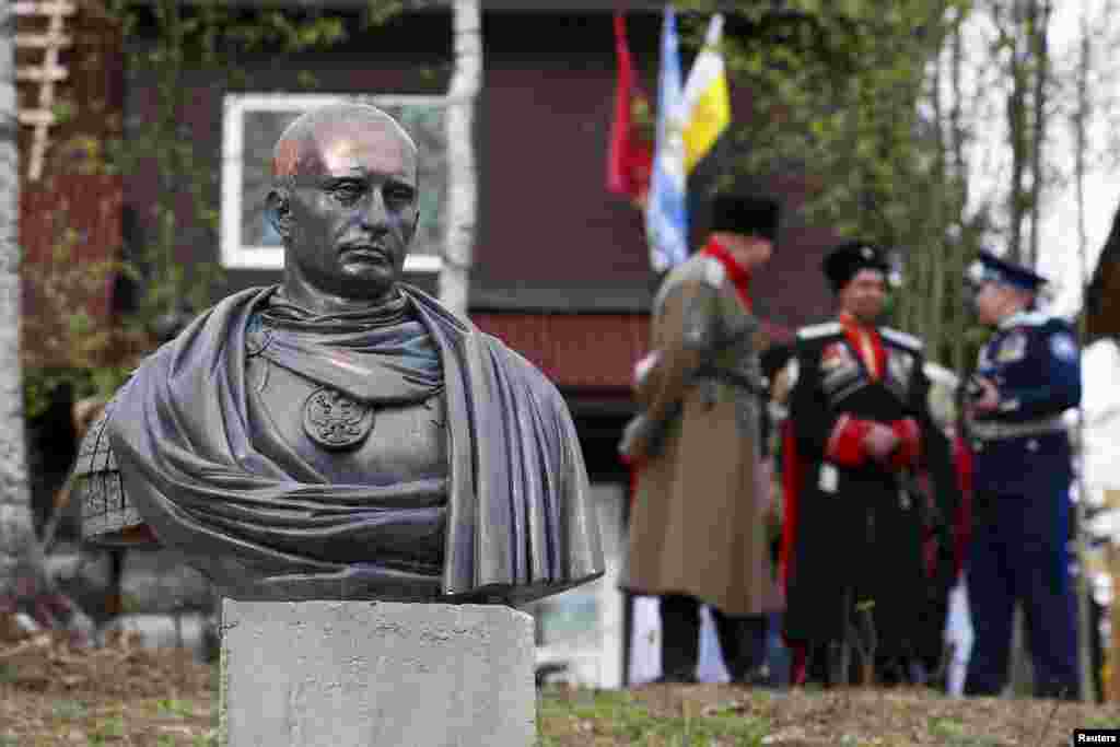 Cossacks stand behind a bust of Russian President Vladimir Putin that depicts him as a Roman emperor, during its unveiling ceremony in the Leningrad region on May 16. (Reuters/Maksim Zmeyev)&nbsp;