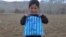 Murtaza Ahmadi, 5, poses with his plastic-bag jersey in January 2016.