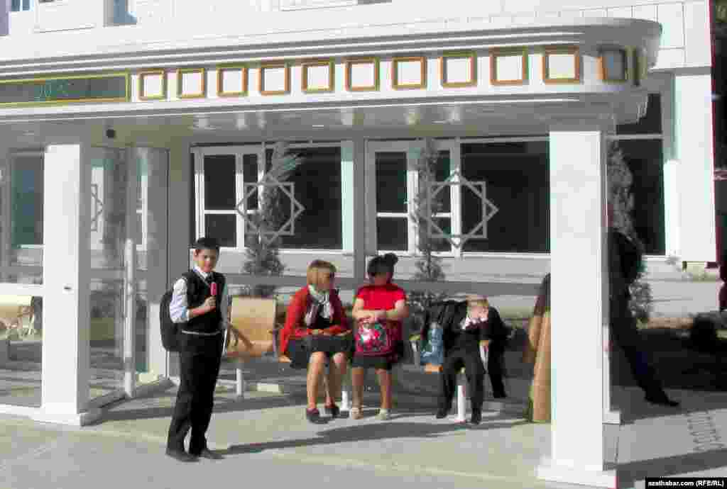 Aşgabadyň awtobus duralgalarynyň birinde jemgyýetçilik transportyna garaşýan mekdep okuwçylary we zenanlar