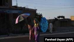 Afghan schoolgirls walk along a street on the outskirts of Mazar-e Sharif (file photo)