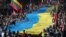 Lithuanians carry a giant Ukrainian flag to protest against the Russian invasion of Ukraine, in Vilnius in March 2022.