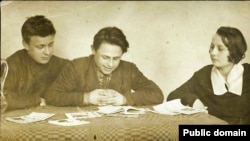 Валеры Маракоў, Янка Бобрык і Яўгенія Пфляўмбаўм разглядаюць кнігі зь бібліятэкі «Маладняка». Менск, 1925 год