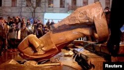 People surround a statue of Soviet state founder Vladimir Lenin that was toppled by protesters during a rally organized by supporters of EU integration in Kyiv on December 8, possibly setting off the rash of Lenin-idolatry abuse.