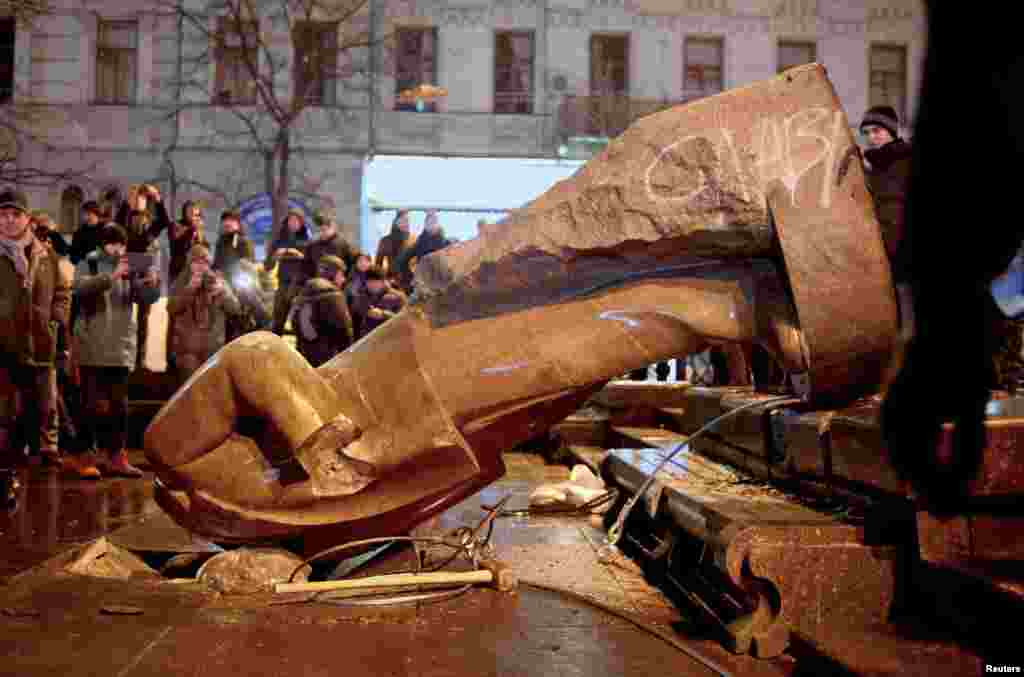 People surround a statue of Soviet state founder Vladimir Lenin, which was toppled by protesters during a rally organized by supporters of EU integration in Kyiv on&nbsp;December 8, 2013.