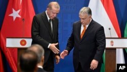 Recep Tayyip Erdoğan török elnök kézfogáshoz készülődik Orbán Viktorral Budapesten 2023. december 18-án