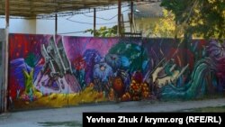 Фантастические пейзажи на заборе летнего кафе