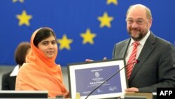 Малала Юсуфзай (сол жақта) Еуропа парламентінің президенті Мартин Шульцтен Сахаров сыйлығын алып тұр. Страсбург, 20 қараша 2013 жыл.