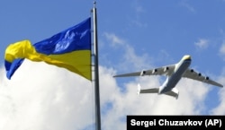 Украинский АН-225 «Мрія», самый большой в мире грузовой самолет, пролетает над майданом Независимости в Киеве во время репетиции военного парада в честь Дня Независимости Украины. Киев, 21 августа 2009 года